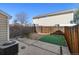 Small fenced backyard with partial lawn, concrete patio, and air conditioning unit at 7234 E 38Th Ave, Denver, CO 80207