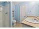 Well-lit bathroom featuring a shower, toilet, and sink with light blue walls at 7234 E 38Th Ave, Denver, CO 80207