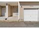 Exterior view of a townhouse with a one-car garage, covered front porch and neutral siding at 7234 E 38Th Ave, Denver, CO 80207