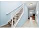 A carpeted staircase with white railings leads to the upper level of the home at 7234 E 38Th Ave, Denver, CO 80207