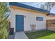 Rear of home with artificial lawn, wood fence, modern landscaping, and blue door at 3188 W 28Th Ave, Denver, CO 80211