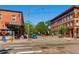 Bustling street corner featuring brick buildings, local businesses, street signs, and crosswalks at 3188 W 28Th Ave, Denver, CO 80211