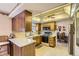 Well-lit kitchen with wood cabinets, white countertops, and modern appliances, open to dining area at 4056 E Orchard Rd, Centennial, CO 80121