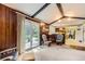 Cozy living room featuring wood paneling, exposed beams and sliding glass doors leading to the patio at 4056 E Orchard Rd, Centennial, CO 80121