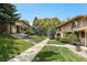 View of a townhouse community with lush green lawns and mature trees at 3210 S Oneida Way, Denver, CO 80224