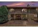 Dusk view of a brick townhouse featuring arched windows and a covered entrance at 3210 S Oneida Way, Denver, CO 80224