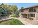 Charming brick townhome featuring arched windows, iron railings, covered porch, and well-maintained landscaping at 3210 S Oneida Way, Denver, CO 80224