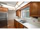 Charming kitchen featuring wood cabinets, stainless steel appliances and a double basin sink at 3210 S Oneida Way, Denver, CO 80224