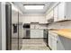 Galley kitchen featuring stainless steel appliances and white cabinets at 13950 E Oxford Pl # A115, Aurora, CO 80014