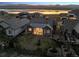 Stunning aerial view of lakefront home with manicured lawn and outdoor patio against a beautiful sunset backdrop at 2882 Heron Lakes Pkwy, Berthoud, CO 80513