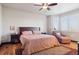 Cozy bedroom featuring a king-size bed, wood floors, decorative rug, accent chair, and natural light at 2882 Heron Lakes Pkwy, Berthoud, CO 80513