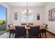 Bright dining room with wood table, black chairs, window shutters, and a view of the lush backyard at 2882 Heron Lakes Pkwy, Berthoud, CO 80513