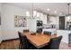 Dining room with wood table, black chairs, and white walls, adjacent to kitchen with stainless steel appliances at 2882 Heron Lakes Pkwy, Berthoud, CO 80513