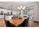Open concept dining area featuring a wooden table, leather chairs, and a view of the kitchen and living area at 2882 Heron Lakes Pkwy, Berthoud, CO 80513