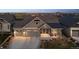 Charming home featuring stone accents, a three-car garage, and covered porch with seating area at 2882 Heron Lakes Pkwy, Berthoud, CO 80513