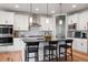 Modern kitchen featuring white cabinets, stainless steel appliances, pendant lighting, and an island with bar seating at 2882 Heron Lakes Pkwy, Berthoud, CO 80513