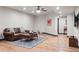 Cozy living room with wood floors, a leather sofa, and ample natural light at 2882 Heron Lakes Pkwy, Berthoud, CO 80513