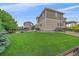 Large, green backyard with garden beds, patio, and a view of the home's exterior at 23831 Eagle Bend Ln, Parker, CO 80138