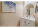 Powder room features a white vanity with sleek hardware, contemporary artwork, and an oval mirror at 23831 Eagle Bend Ln, Parker, CO 80138