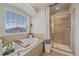 Bright bathroom featuring a soaking tub with a wood caddy and a tiled glass-door shower at 23831 Eagle Bend Ln, Parker, CO 80138