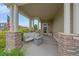 Cozy front porch with stone columns and comfortable seating, perfect for relaxing outdoors at 23831 Eagle Bend Ln, Parker, CO 80138