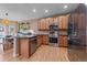 A well-lit kitchen with stainless steel appliances, wooden cabinets, and a kitchen island adjacent to the dining area at 23831 Eagle Bend Ln, Parker, CO 80138