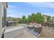 Back patio with cushioned seating, grill and a green lawn with manicured garden beds in the distance at 23831 Eagle Bend Ln, Parker, CO 80138