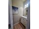 Cozy powder room featuring a white vanity, round mirror, and stylish lighting at 23831 Eagle Bend Ln, Parker, CO 80138
