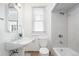 Well-lit bathroom featuring a window, toilet, and tub with shower at 2826 Quitman St, Denver, CO 80212