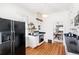 Sunlit kitchen featuring a gas range, floating shelves, and hardwood flooring at 2826 Quitman St, Denver, CO 80212