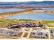 Aerial view of a golf course clubhouse with lake and mountain views at 2366 Shoreside Dr, Berthoud, CO 80513