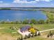 Stunning aerial view of lakeside property with a custom home, mature trees, and scenic water views at 2366 Shoreside Dr, Berthoud, CO 80513