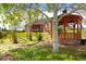 Gazebo in landscaped backyard of brick home with manicured lawn and mature trees at 2366 Shoreside Dr, Berthoud, CO 80513