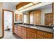 Bright bathroom featuring dual sinks and a vanity with granite counters and custom cabinetry at 2366 Shoreside Dr, Berthoud, CO 80513