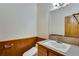 Half bathroom with a toilet, vanity, and wood paneling at 2366 Shoreside Dr, Berthoud, CO 80513