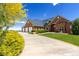 Beautiful brick home with a manicured lawn, three-car garage, and mature landscaping at 2366 Shoreside Dr, Berthoud, CO 80513