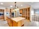 Bright kitchen with wood cabinets, a central island, and built-in appliances at 2366 Shoreside Dr, Berthoud, CO 80513