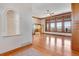Spacious living room features hardwood floors, a ceiling fan, and tall windows with wood trim at 2366 Shoreside Dr, Berthoud, CO 80513