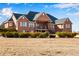Rear exterior view of brick home featuring a walk out basement and lush landscaping at 2366 Shoreside Dr, Berthoud, CO 80513