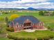Aerial of the back exterior of brick home features a patio and stairwell with expansive green lawn at 2366 Shoreside Dr, Berthoud, CO 80513
