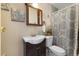 Cozy bathroom showcasing a dark wood vanity, decorative mirror, and patterned shower curtain at 9410 Cedar Ct, Thornton, CO 80229