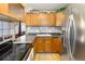 Functional kitchen with wooden cabinets, sleek countertops, and stainless steel appliances at 9410 Cedar Ct, Thornton, CO 80229