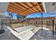 Covered back patio with open beam ceiling, concrete floor, and iron fencing is perfect for outdoor entertaining at 7746 S Harrison Cir, Centennial, CO 80122