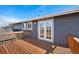 Back porch with brown wooden floor and gray vinyl siding with a white trim at 7746 S Harrison Cir, Centennial, CO 80122