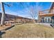 Beautiful backyard with tiered stone walls, mature trees, and a deck, perfect for outdoor entertaining at 7746 S Harrison Cir, Centennial, CO 80122
