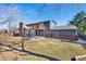Expansive backyard features a covered patio, upper level deck, brick chimney, and lush lawn at 7746 S Harrison Cir, Centennial, CO 80122