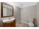 Basement powder room with decorative vanity, wood trim, and a modern toilet at 7746 S Harrison Cir, Centennial, CO 80122