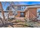Exterior shot of a charming red brick home with a grey front door and white picket fence detail at 7746 S Harrison Cir, Centennial, CO 80122