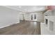 Spacious living room with a painted brick fireplace, wood mantel, and access to the backyard at 7746 S Harrison Cir, Centennial, CO 80122