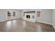 Bright living room with painted brick fireplace, wooden mantel, and glass doors to the backyard at 7746 S Harrison Cir, Centennial, CO 80122